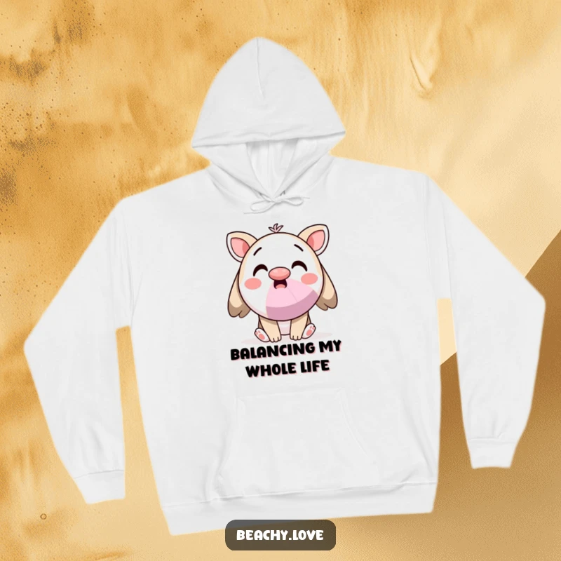 Funny hoodie with a surprised kawaii character balancing a beach ball on its nose, exuding playful charm and warmth.
